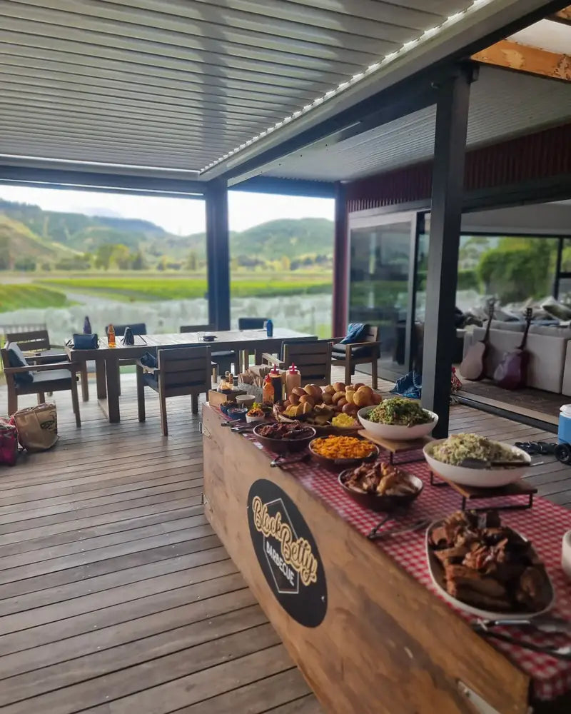 A Black Betty catering spread laid out on a covered deck looking over the valley