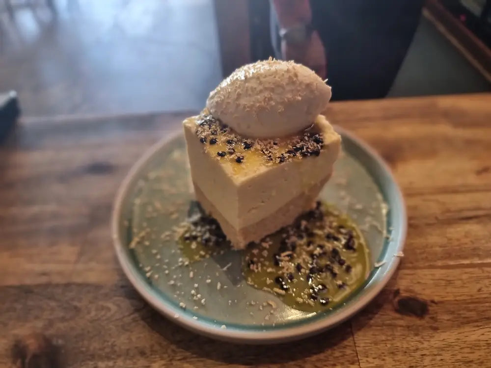 A salted caramel slice with a scoop of hokey pokey ice cream on a green ceramic plate